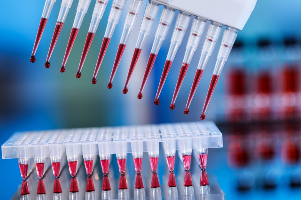 Red liquid samples being placed in test tubes