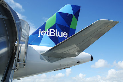 Tail wing of JetBlue Airbus A321 airplane flying in the sky.