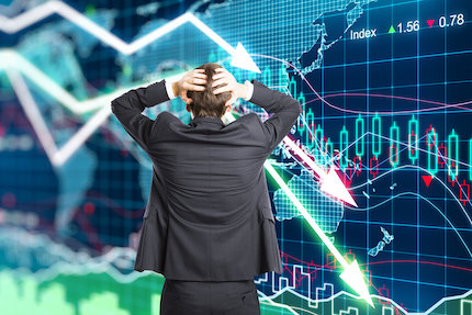 Man upset looking at stock charts going in a downward direction.