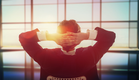 Young business man looking out windows in office