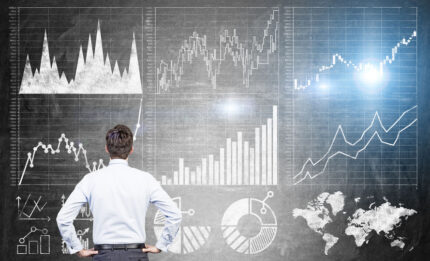 Man looking at stock charts superimposed on background that resembles a blackboard.