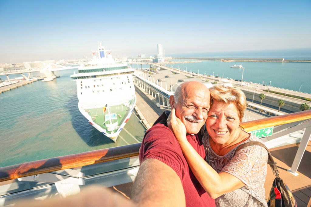 Senior happy couple taking selfie on ship at Barcelona harbour background