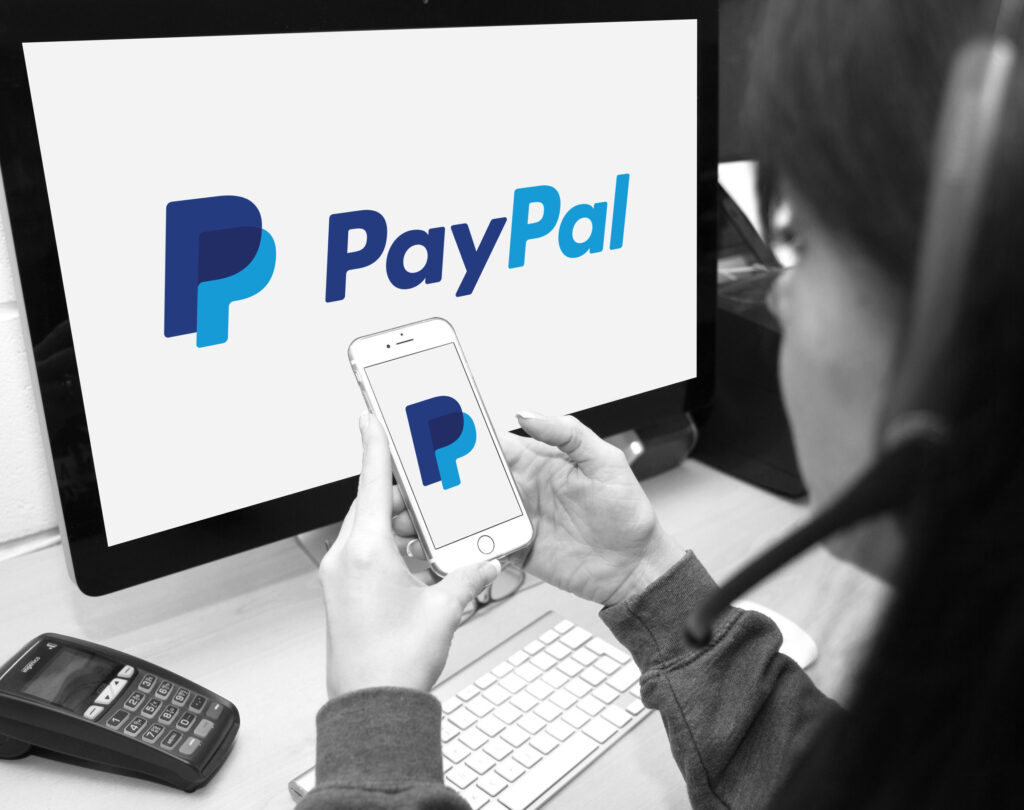 Person using PayPal website and smartphone app