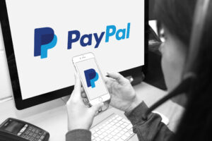 Member of staff using PayPal website and smartphone app to provide customers with support