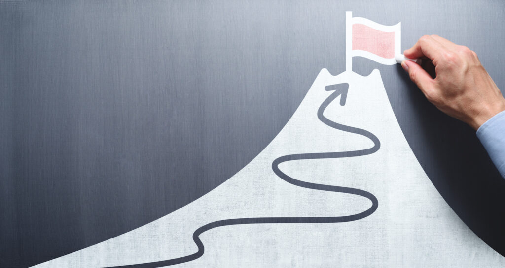 selling covered calls: man drawing a hill with a flag on top