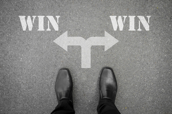 Black business shoes in front of "win-win" written on the sidewalk