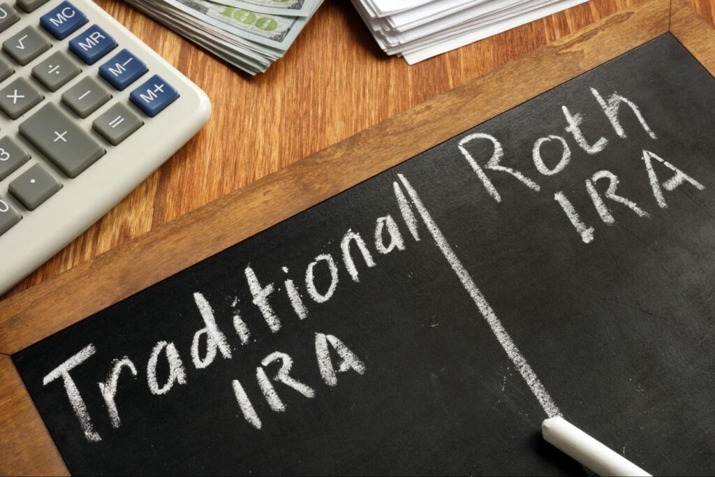 Traditional IRA and Roth IRA written on a blackboard on top of a wooden table