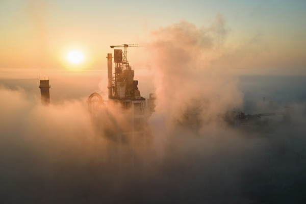 Cement factory or oil refiner in the fog