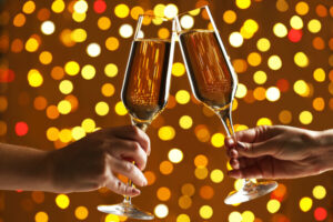 Hands holding champagne glasses on lights background