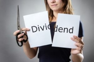 stand woman cutting paper in half with the word share capital written on the paper