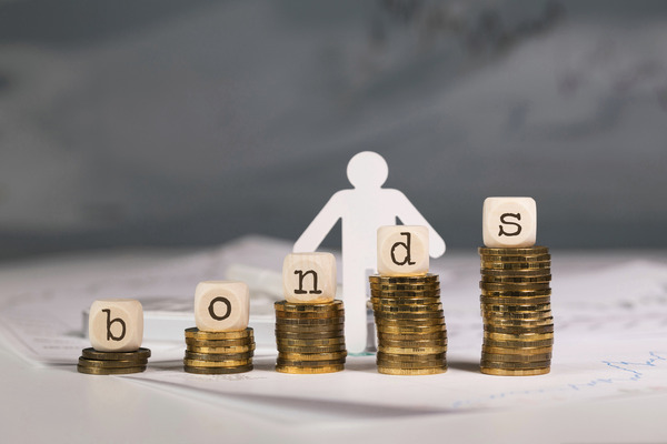 Letters spelling out "BONDS" on top of stacks of coins