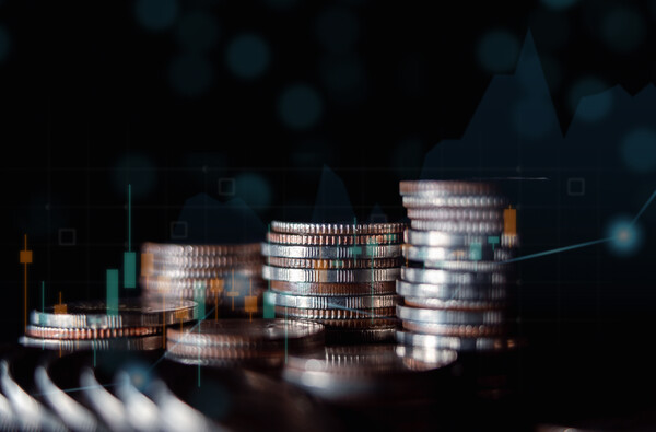 Rising stacks of coins against dark background
