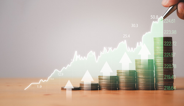 Rising stock chart overlaid on stacks of coins