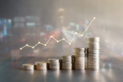 Chart with upward arrows over stock of coins evoking a feeking of wealth growth.