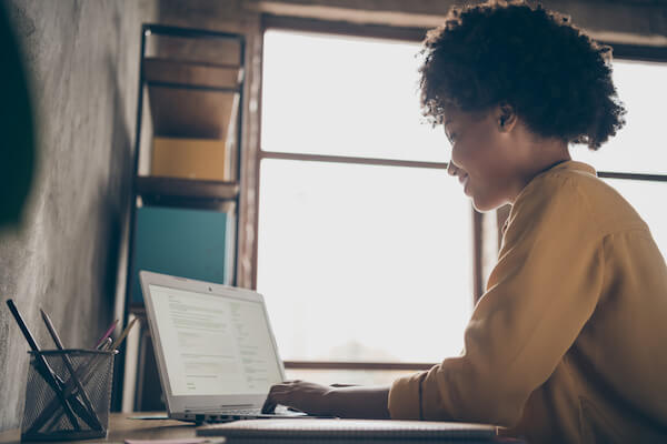 income producing assets: Smiling woman using a laptop