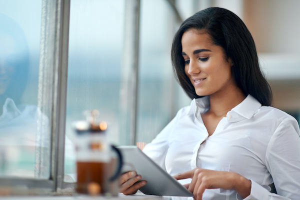 Woman smiling while using her tablet