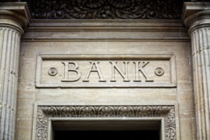 Old bank sign engraved in stone or concrete above the door of financial building concept for finance and business