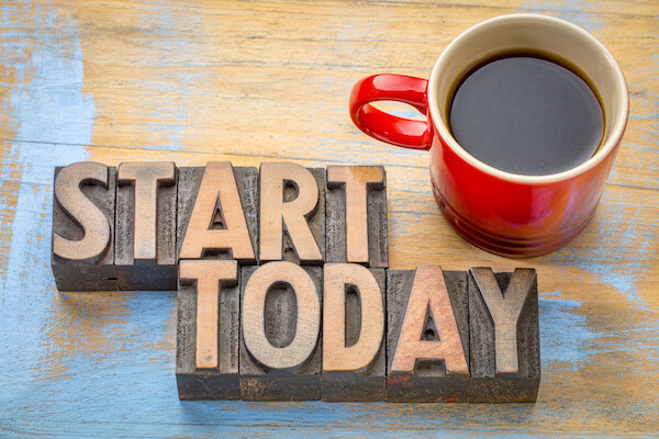 START TODAY in wooden blocks beside a mug of coffee