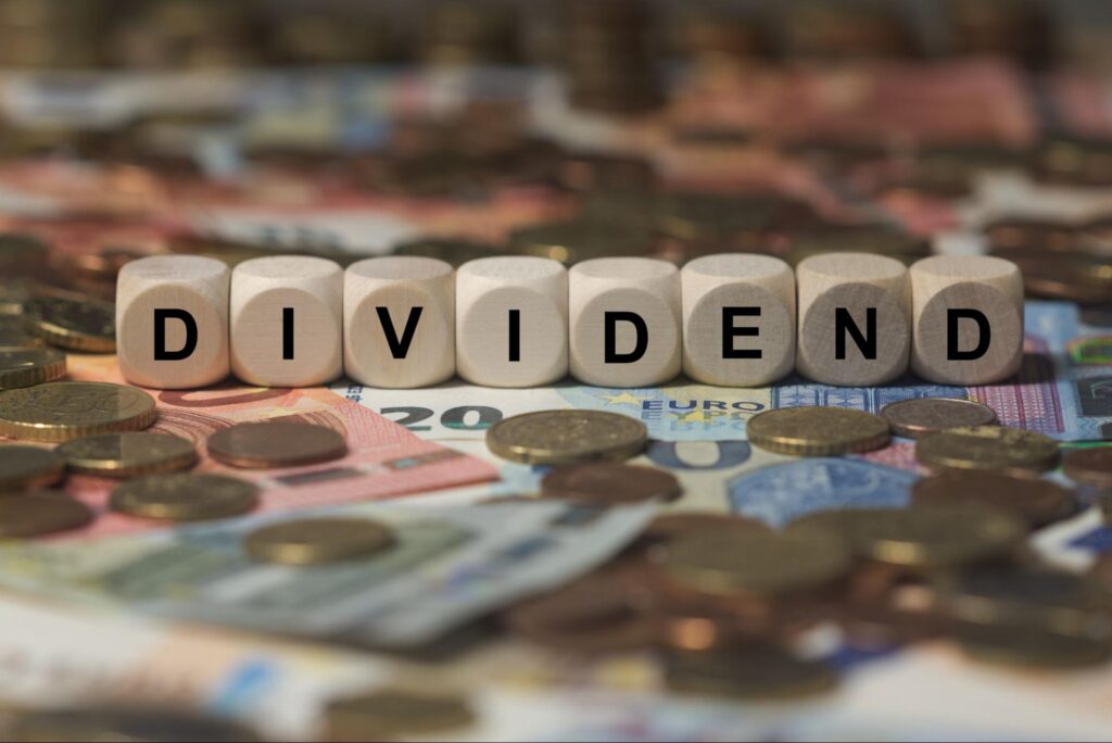 capital gains yield: dividend spelled in cubes with letters surrounded with lots of money