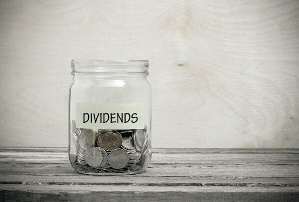 dividend rate: coins in a mason jar labeled with DIVIDENDS