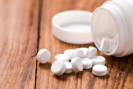 Round pills on a wooden table.