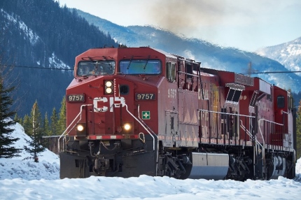 Canadian Pacific locomotive in snow with mountains in the background.