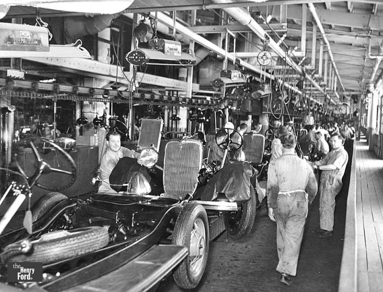 Cars being produced on an assembly line from 1920s.