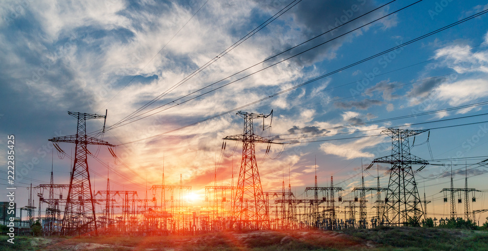 High tension power lines with the sunset behind them.