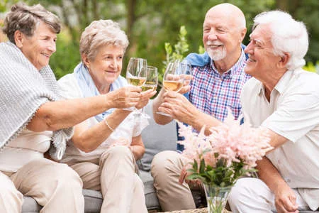Group of older people drinking wine together.