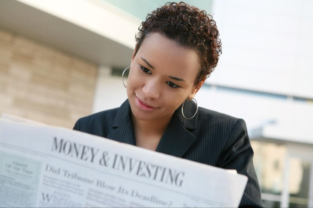 high yield investments: woman reading a newspaper