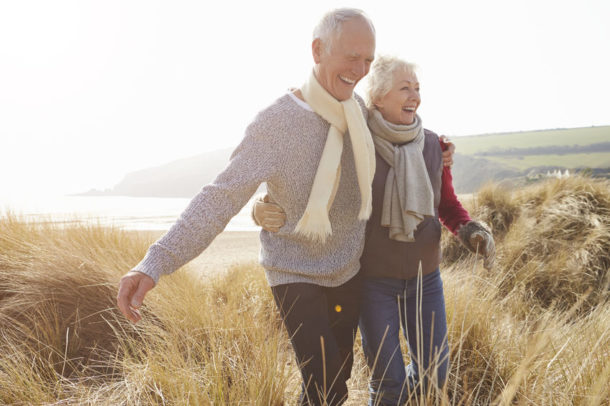 Older couple walking through a field.