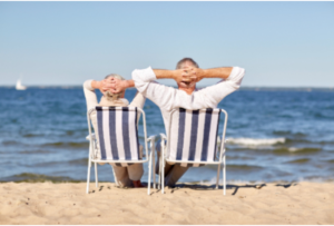 Elderly people sitting in chairs at the beach.
