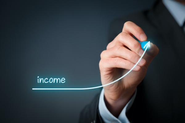 Man writing income and drawing an upwards line