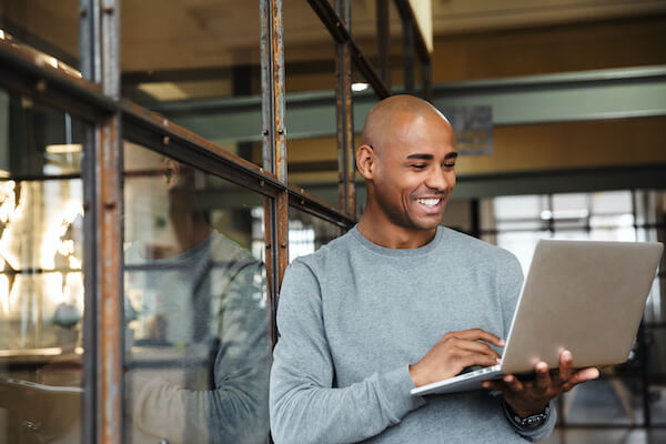 put vs call: man smiling while holding his laptop