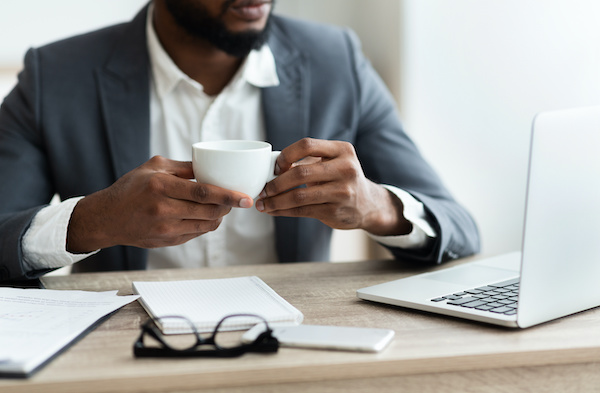 man working while having a cup of coffe