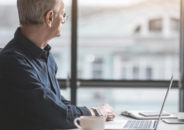 Income investing strategy: old businessman looking out the window