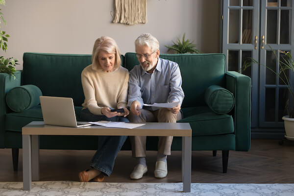 Old couple talking while sitting on a couch