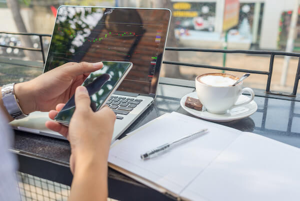 person checking their mobile phone while having coffee