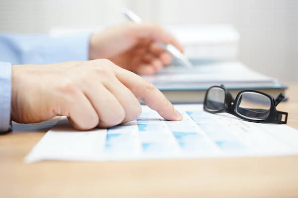 portfolio income: person pointing out some data on paper