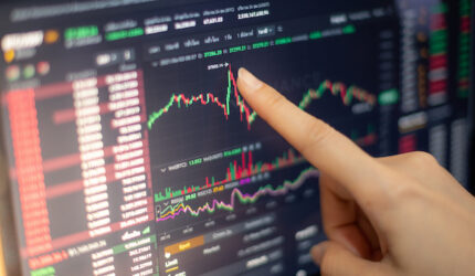 The business woman investor trading or stock brokers having a planning and analyzing with display screen and pointing on the data presented and deal on a stock exchange.