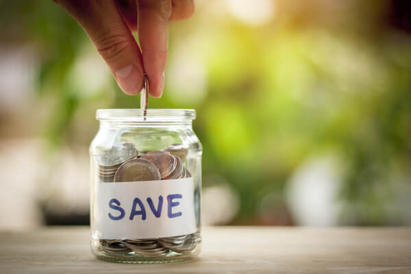 person putting a coin in a jar