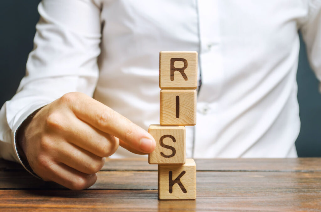 person using blocks to spell out the word risk