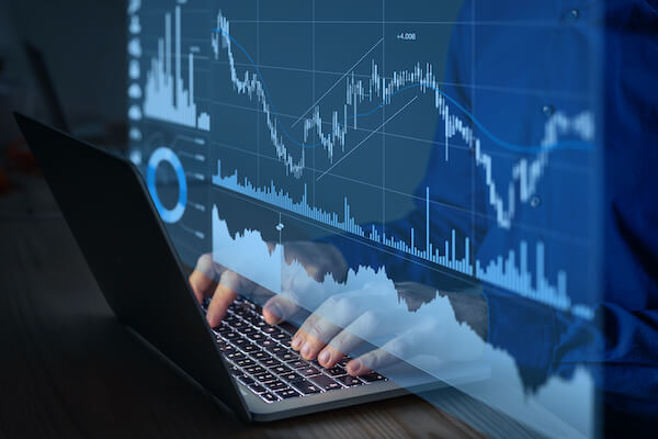 covered call ETF: person typing with graphs on the screen