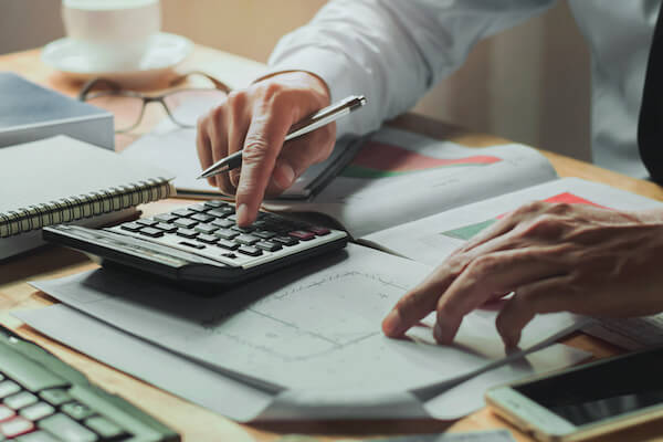 Person inputting numbers from a document into a calculator