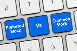 Preferred Stock Vs. Common Stock Written on Blue Key of Metallic Keyboard. Finger pressing key.