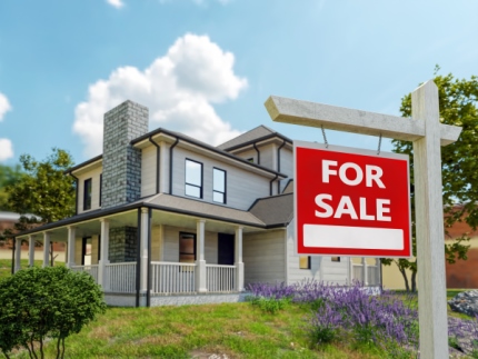 Multi-level home with For Sale sign in front.