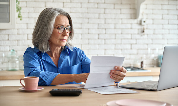 free retirement stock: woman reading documents on her desk