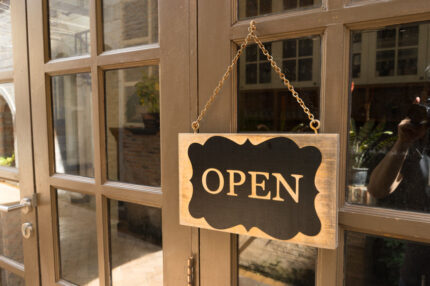 Wooden board sign that says Open from a restaurant